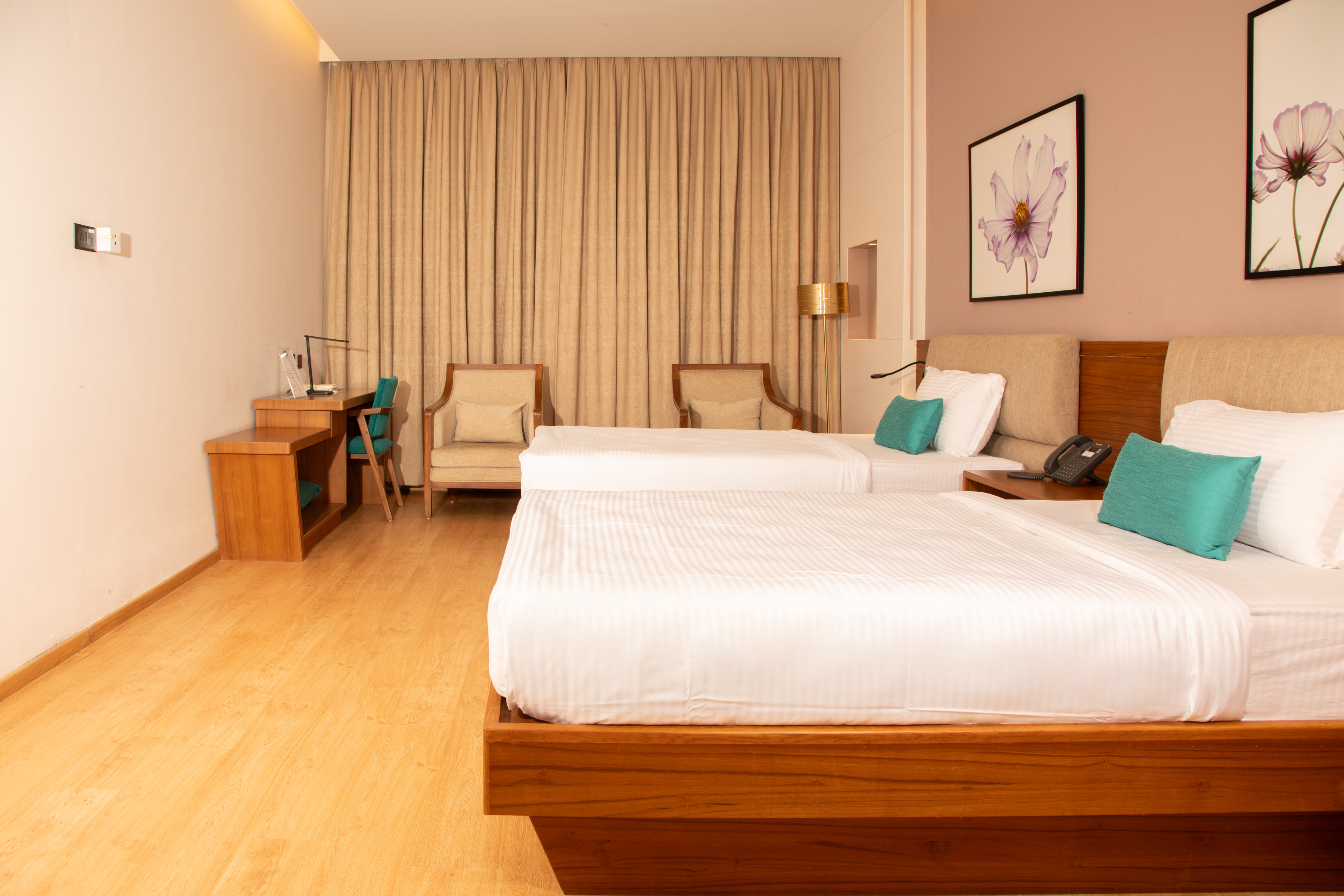 A Wellness Deluxe room: two beds, armchairs by the window and warm cove lighting. — photo 2