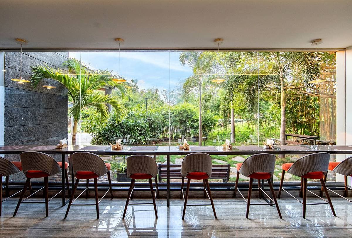 The restaurant at The Pearl: a long table and chairs running the length of a glazed wall open to the garden.