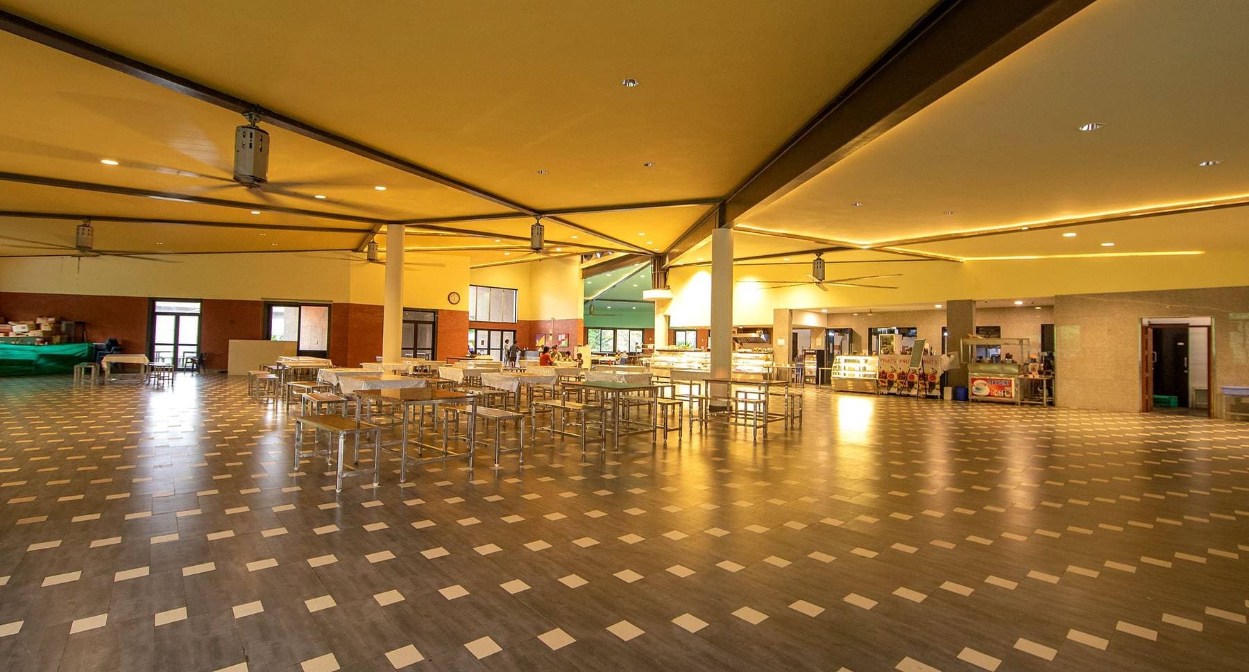 The large hall at Kanha: rows of tables under a broad timber ceiling, empty between sittings.