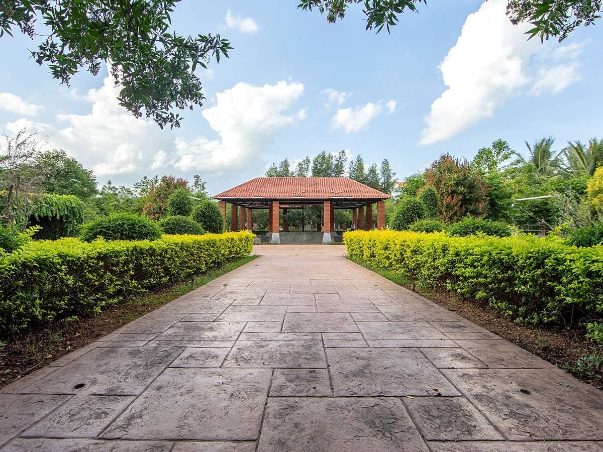 A paved avenue between clipped hedges leading to a tiled pavilion at Kanha.